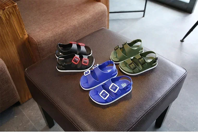 Chaussure de plage enfant – Modèle bleu et vert avec boucles, vue d'ensemble sur un meuble en cuir